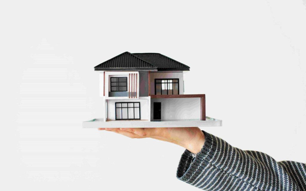 Hand Presenting Model House For Home Loan Campaign